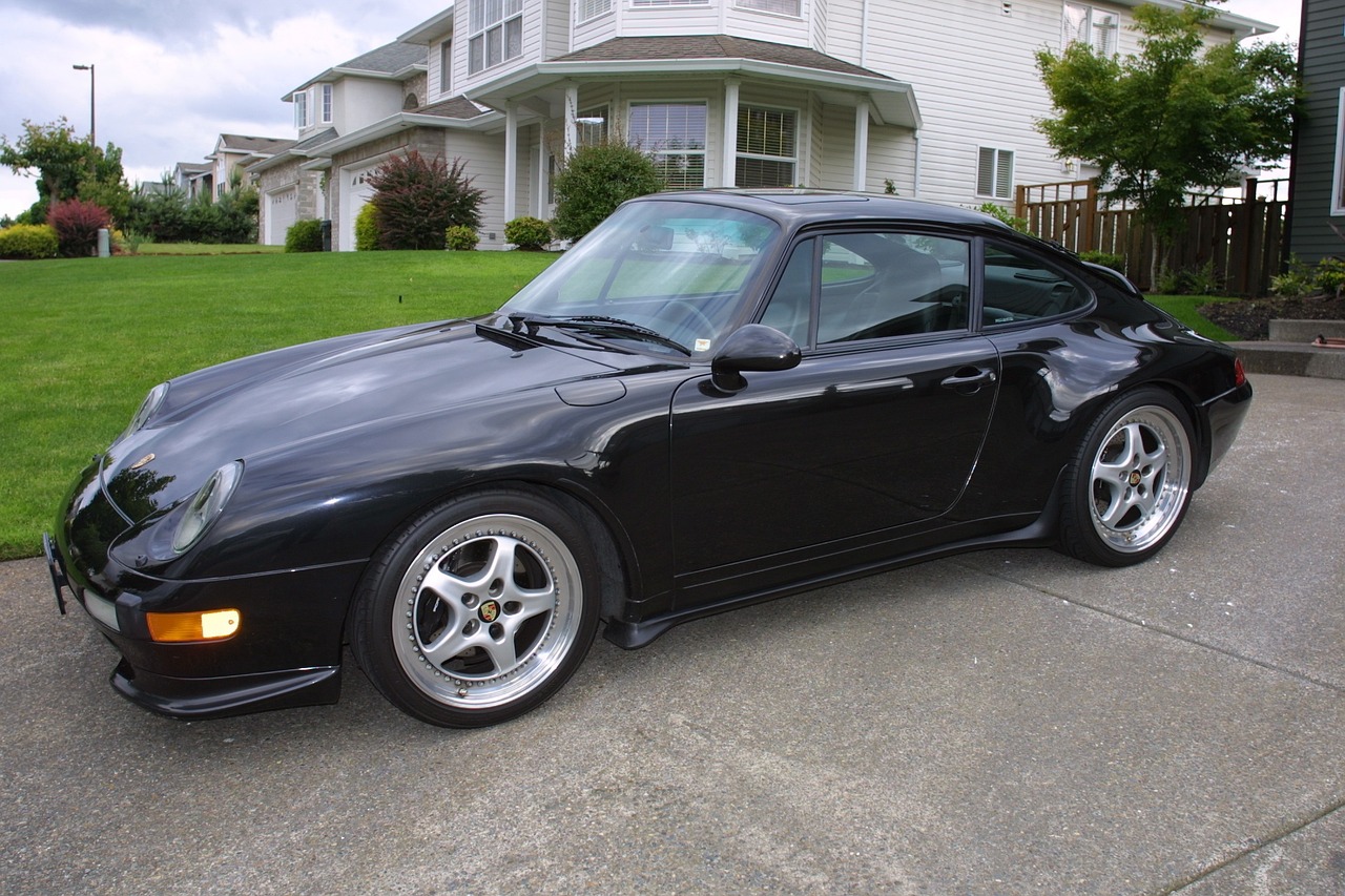 Photo of a black sedan parked in front of a mansion